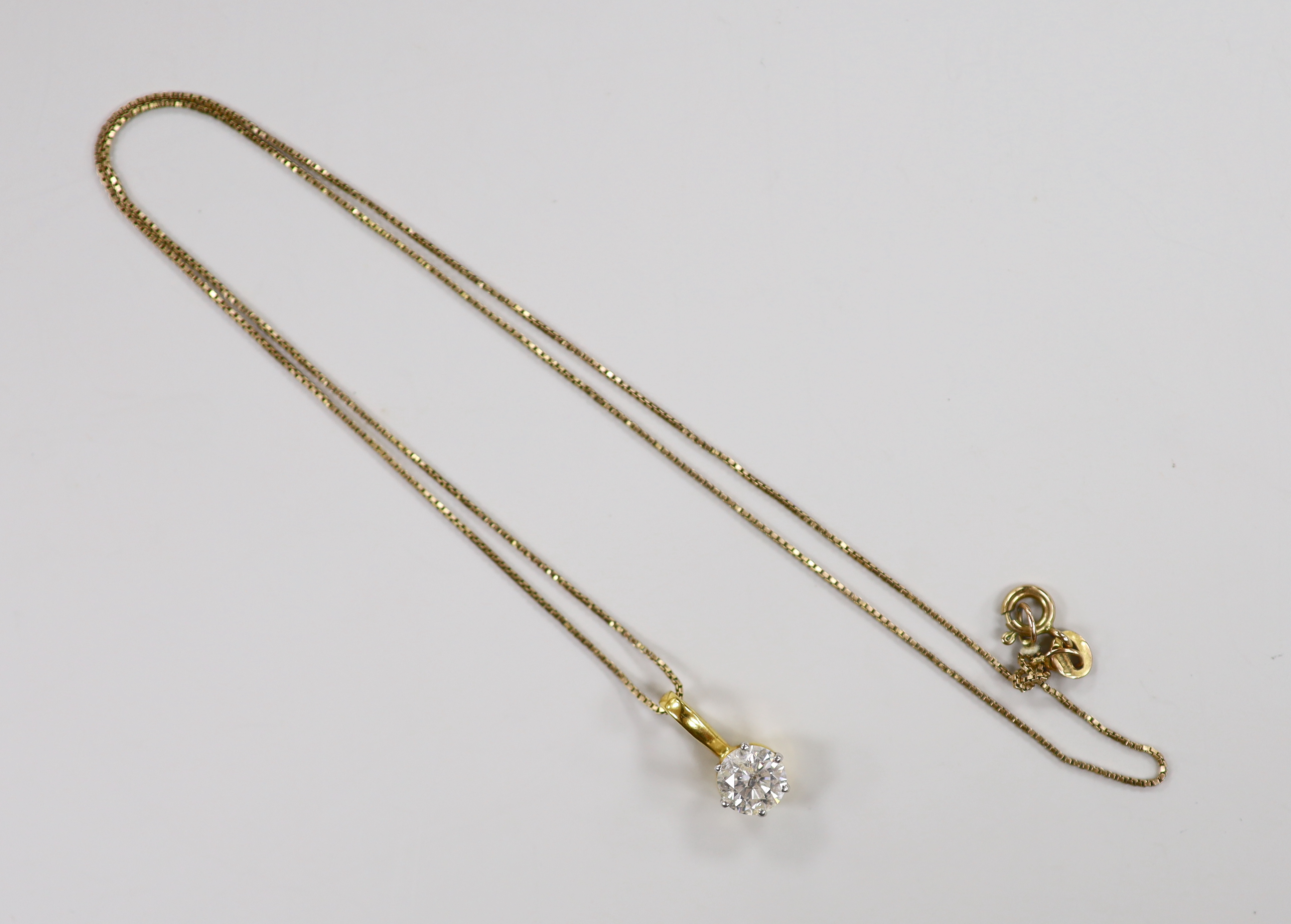 A yellow metal and solitaire diamond set pendant, 15mm, on a 9ct chain, 42cm, gross weight 2.7 grams.